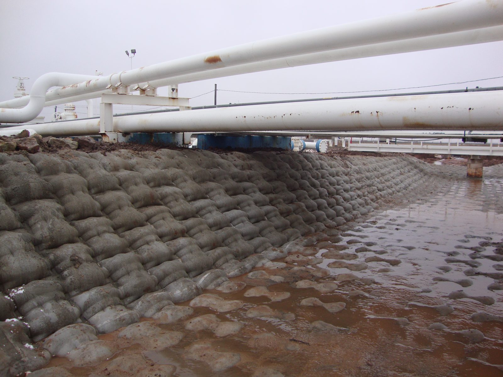 After: The same drainage lined beneath the pipe racks