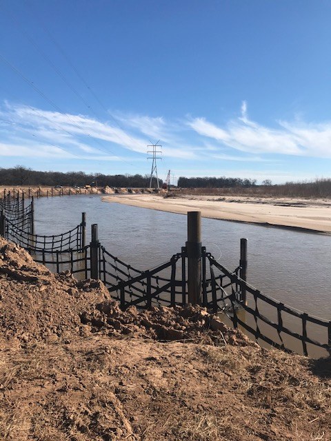Structures installed along a riverbank beneath a transmission line